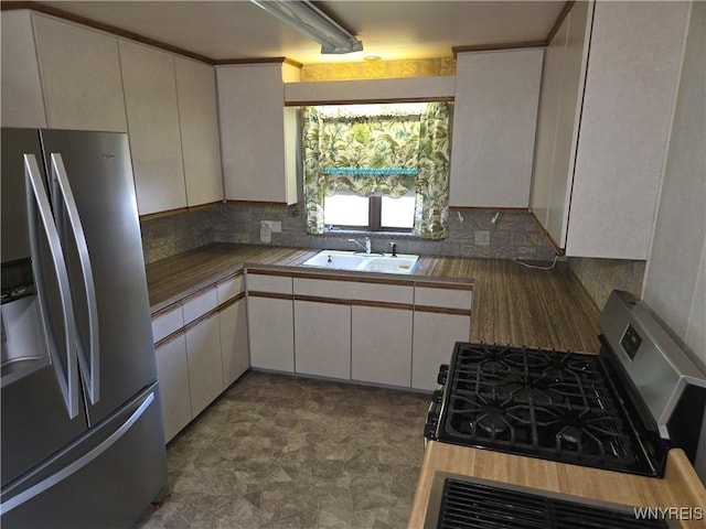 2595 Jerauld Ave, Niagara Falls, NY 14305 - kitchen with stainless steel appliances, decorative backsplash, white cabinets, and stone finish floors