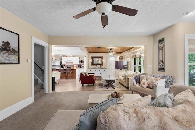 639 Plank Rd, Penfield, NY 14580 - living area featuring ceiling fan, plenty of natural light, carpet flooring, a textured ceiling, and stairs