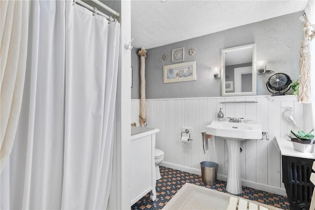639 Plank Rd, Penfield, NY 14580 - bathroom with a wainscoted wall, curtained shower, a textured ceiling, and tile patterned floors