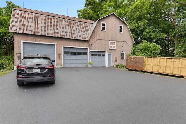 639 Plank Rd, Penfield, NY 14580 - view of front of property with a gambrel roof, a detached garage, a metal roof, and an outdoor structure