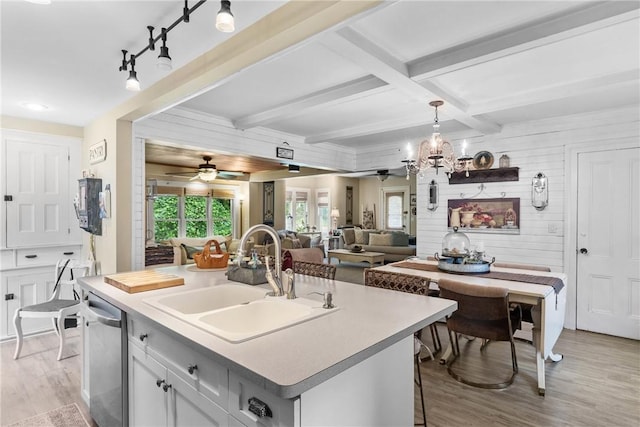 639 Plank Rd, Penfield, NY 14580 - kitchen featuring light wood-style floors, wood walls, light countertops, beam ceiling, and stainless steel dishwasher