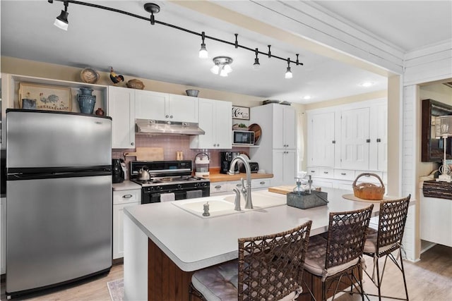 639 Plank Rd, Penfield, NY 14580 - kitchen featuring black appliances, track lighting, under cabinet range hood, light countertops, and light wood-type flooring
