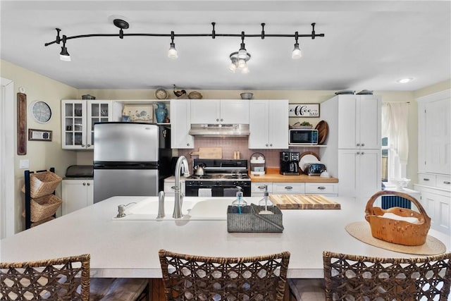 639 Plank Rd, Penfield, NY 14580 - kitchen with black appliances, under cabinet range hood, track lighting, butcher block counters, and white cabinetry