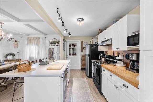 639 Plank Rd, Penfield, NY 14580 - kitchen with black appliances, under cabinet range hood, light wood finished floors, and white cabinetry