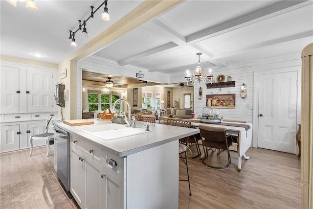 639 Plank Rd, Penfield, NY 14580 - kitchen with a breakfast bar area, light wood-type flooring, dishwasher, an island with sink, and light countertops