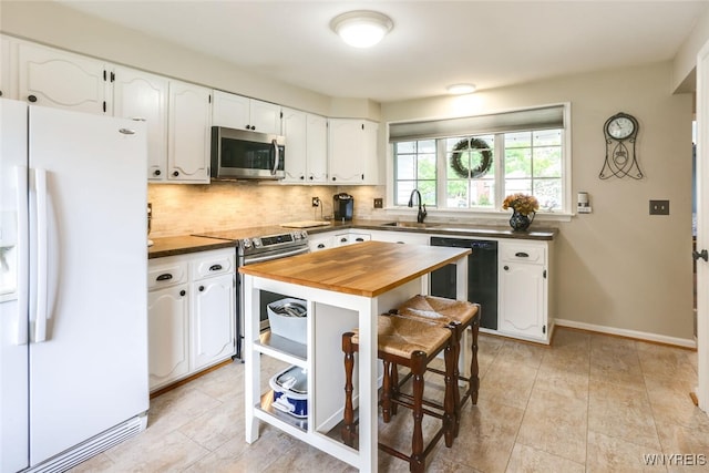 92 Bridle Path, Amherst, NY 14221 - kitchen featuring stainless steel appliances, wooden counters, decorative backsplash, and white cabinets