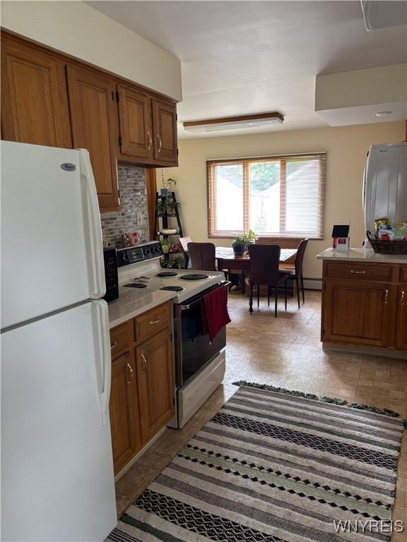 126 N 8th St, Olean-City, NY 14760 - kitchen featuring white appliances, tasteful backsplash, brown cabinetry, and light countertops