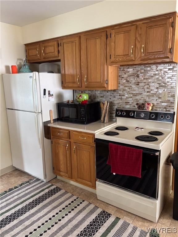 126 N 8th St, Olean-City, NY 14760 - kitchen with white appliances, light countertops, backsplash, brown cabinets, and light tile patterned flooring