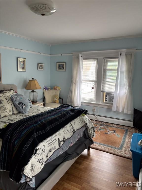 126 N 8th St, Olean-City, NY 14760 - bedroom featuring cooling unit, a baseboard heating unit, ornamental molding, and wood finished floors