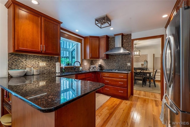 20 Dan Troy Dr, Amherst, NY 14221 - kitchen featuring stainless steel appliances, wall chimney exhaust hood, a peninsula, light wood-style flooring, and decorative backsplash