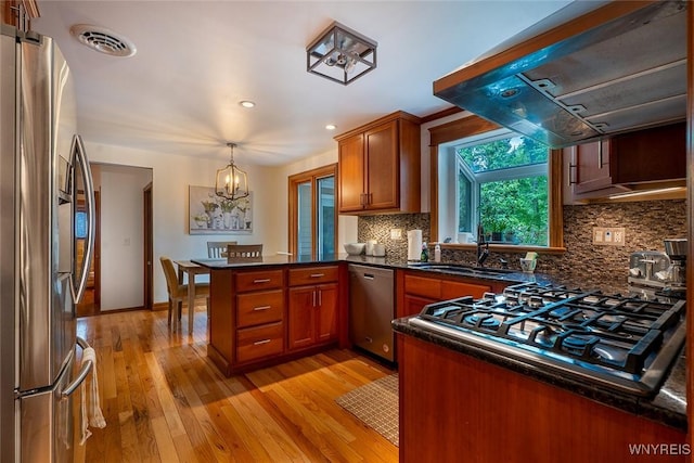 20 Dan Troy Dr, Amherst, NY 14221 - kitchen featuring stainless steel appliances, exhaust hood, a peninsula, light wood-style flooring, and brown cabinetry