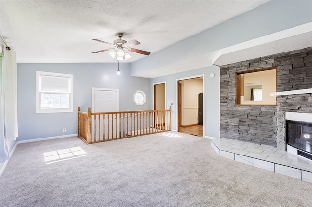 32 Princess Dr, Henrietta, NY 14623 - unfurnished living room with carpet floors, a ceiling fan, a fireplace, a textured ceiling, and vaulted ceiling