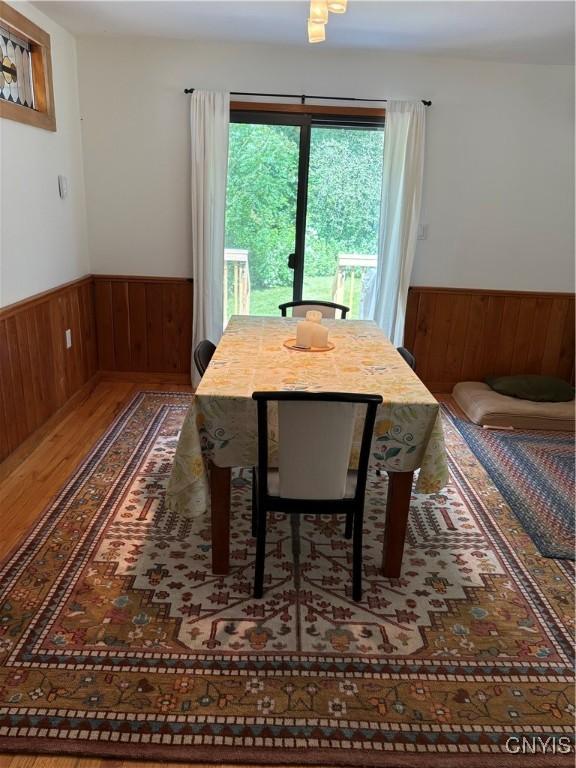 1708 Bonney Rd, Hamilton, NY 13346 - dining space featuring a wainscoted wall, wood finished floors, and wooden walls