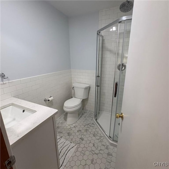 1708 Bonney Rd, Hamilton, NY 13346 - full bathroom featuring vanity, a stall shower, tile walls, a wainscoted wall, and tile patterned floors