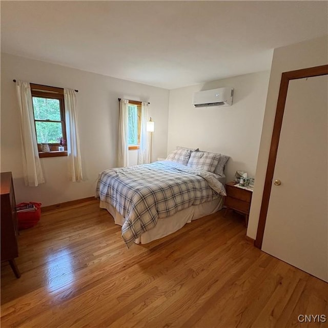 1708 Bonney Rd, Hamilton, NY 13346 - bedroom with a wall mounted air conditioner and light wood-type flooring