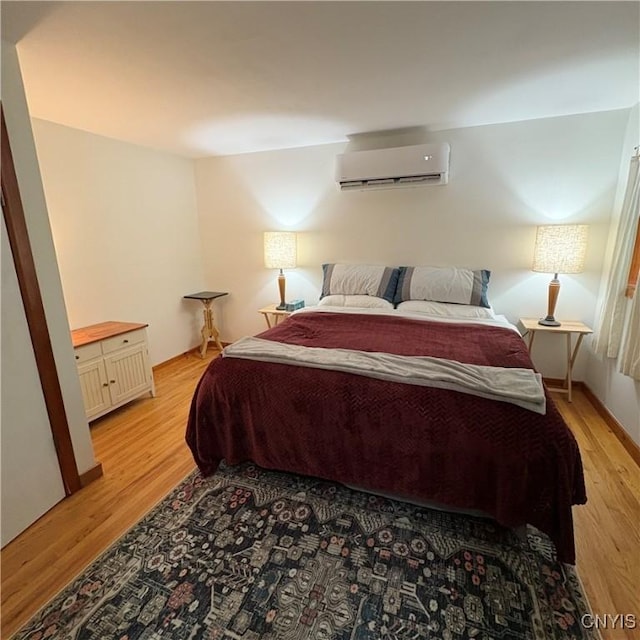 1708 Bonney Rd, Hamilton, NY 13346 - bedroom with an AC wall unit and light wood-style floors