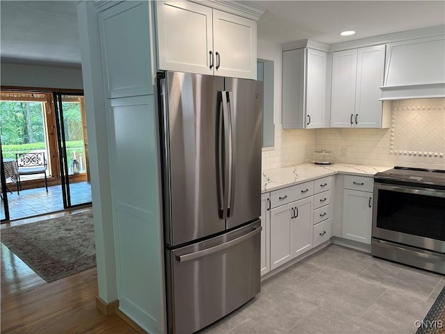 1708 Bonney Rd, Hamilton, NY 13346 - kitchen with stainless steel appliances, tasteful backsplash, light stone countertops, white cabinetry, and recessed lighting