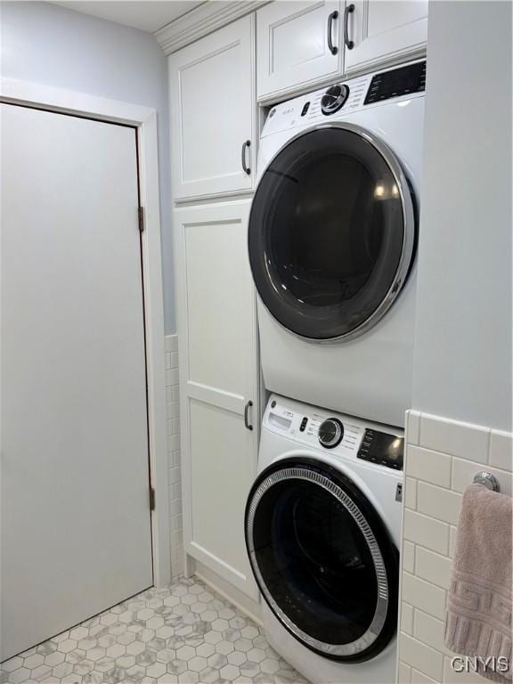 1708 Bonney Rd, Hamilton, NY 13346 - laundry area featuring stacked washer / dryer, cabinet space, and light tile patterned floors