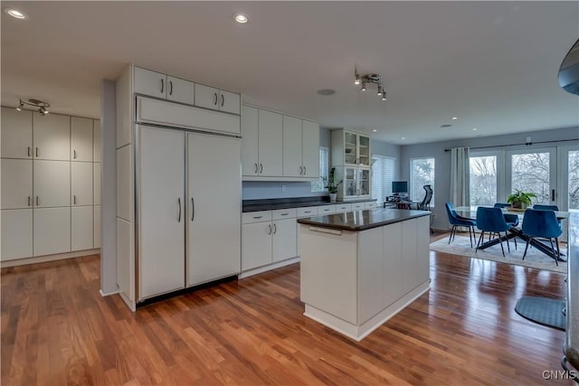 1348 Sunset Rdg, Watertown-Town, NY 13601 - kitchen featuring dark countertops, wood finished floors, a center island, recessed lighting, and white cabinetry