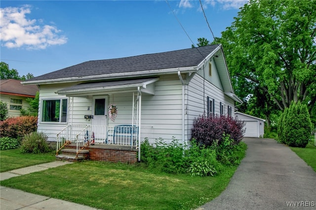 18 Bader Ave, Collins, NY 14070 - bungalow-style house featuring an outbuilding, a front yard, a detached garage, and roof with shingles