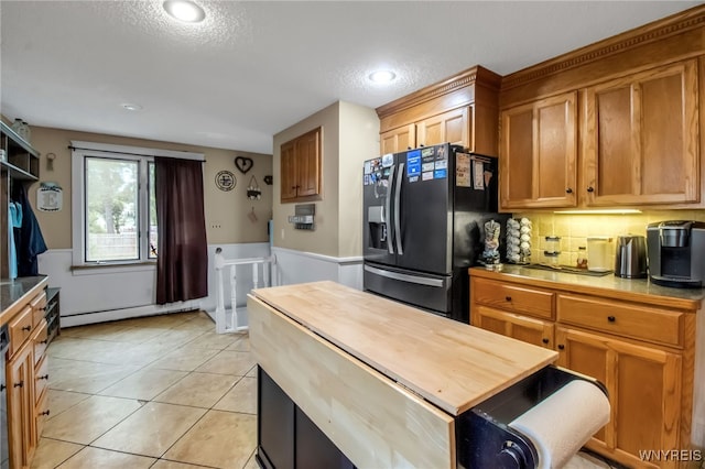 18 Bader Ave, Collins, NY 14070 - kitchen with black refrigerator with ice dispenser, butcher block countertops, a baseboard radiator, a textured ceiling, and wainscoting