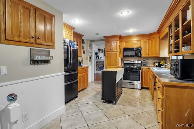 18 Bader Ave, Collins, NY 14070 - kitchen featuring black appliances, glass insert cabinets, light tile patterned floors, a center island, and recessed lighting
