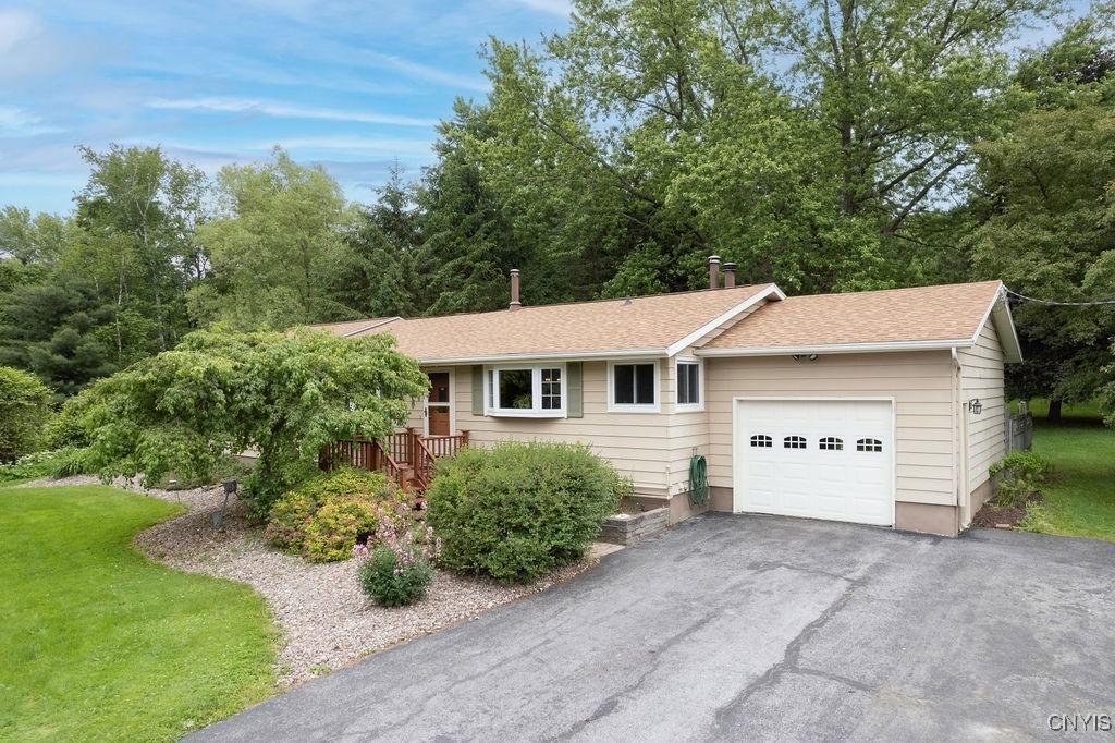 2770 Amber Rd, Marcellus, NY 13110 - single story home featuring a garage, asphalt driveway, roof with shingles, and a front yard