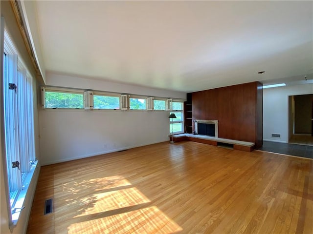 919 Fassett Rd, Elmira, NY 14905 - unfurnished living room featuring wood finished floors and a fireplace with raised hearth