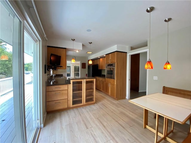 919 Fassett Rd, Elmira, NY 14905 - kitchen featuring oven, dark countertops, freestanding refrigerator, brown cabinetry, and light wood-style flooring