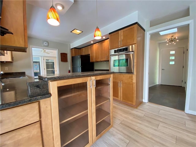 919 Fassett Rd, Elmira, NY 14905 - kitchen with oven, freestanding refrigerator, dark stone counters, and hanging light fixtures