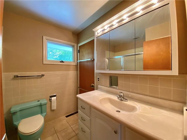 919 Fassett Rd, Elmira, NY 14905 - full bath with tile walls, vanity, tile patterned floors, and an enclosed shower