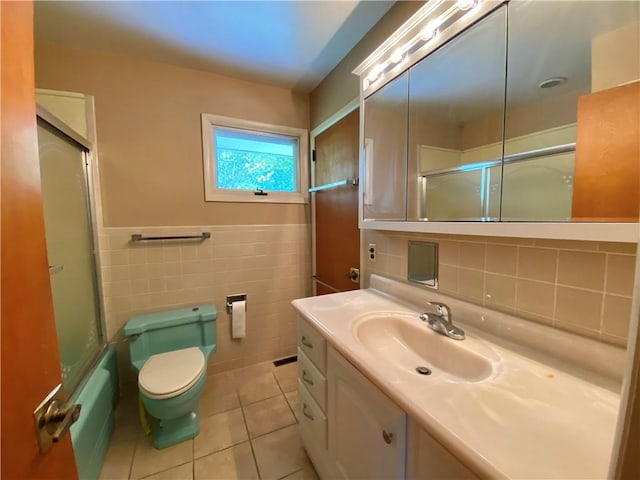 919 Fassett Rd, Elmira, NY 14905 - full bath with tile walls, vanity, tile patterned flooring, and enclosed tub / shower combo