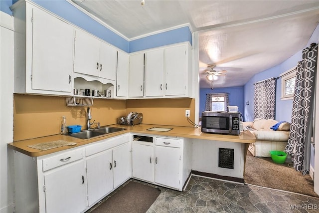 132 Ryan St, Buffalo, NY 14210 - kitchen with stainless steel microwave, white cabinets, ceiling fan, and light countertops