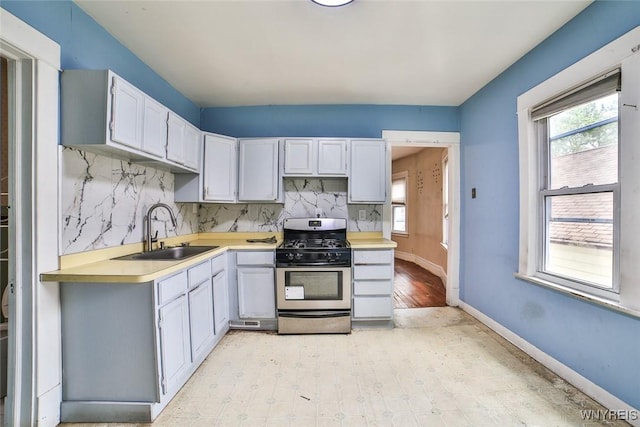 132 Ryan St, Buffalo, NY 14210 - kitchen with stainless steel gas range, light countertops, backsplash, and white cabinetry