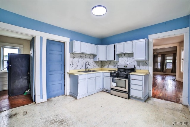 132 Ryan St, Buffalo, NY 14210 - kitchen with gas range, light countertops, decorative backsplash, and freestanding refrigerator