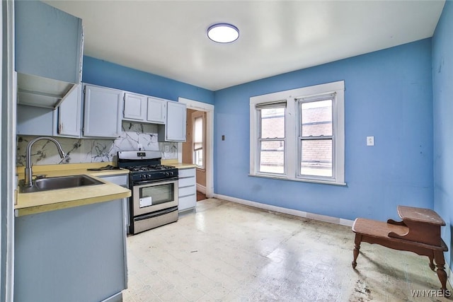 132 Ryan St, Buffalo, NY 14210 - kitchen featuring stainless steel range with gas stovetop, light countertops, decorative backsplash, and white cabinets