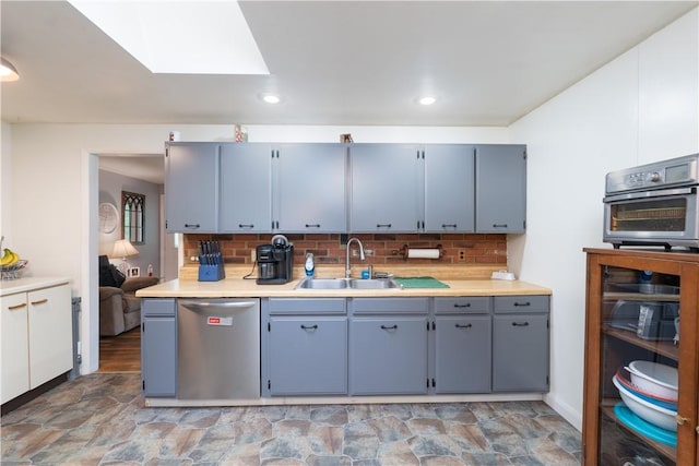 207 County Road 7, Manchester, NY 14432 - kitchen featuring dishwasher, a skylight, light countertops, decorative backsplash, and light stone finish flooring