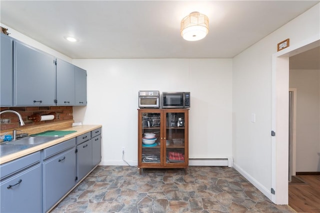 207 County Road 7, Manchester, NY 14432 - kitchen featuring stainless steel microwave, backsplash, a baseboard heating unit, and blue cabinets