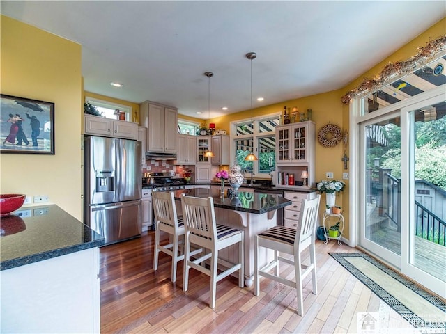 4627 Anderson Dr, Ellery, NY 14712 - kitchen featuring stainless steel fridge, under cabinet range hood, dark countertops, light wood-type flooring, and a breakfast bar