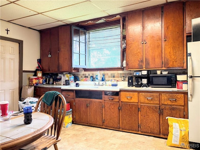 134 Hamburg St, Buffalo, NY 14204 - kitchen featuring black microwave, freestanding refrigerator, light countertops, light floors, and brown cabinets