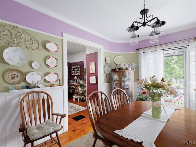 303 Mullin St, Watertown-City, NY 13601 - dining area with a chandelier, wood finished floors, crown molding, and wainscoting
