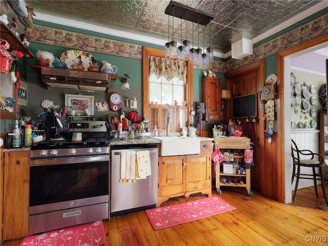 303 Mullin St, Watertown-City, NY 13601 - kitchen with stainless steel appliances, an ornate ceiling, range hood, light wood-style flooring, and brown cabinets