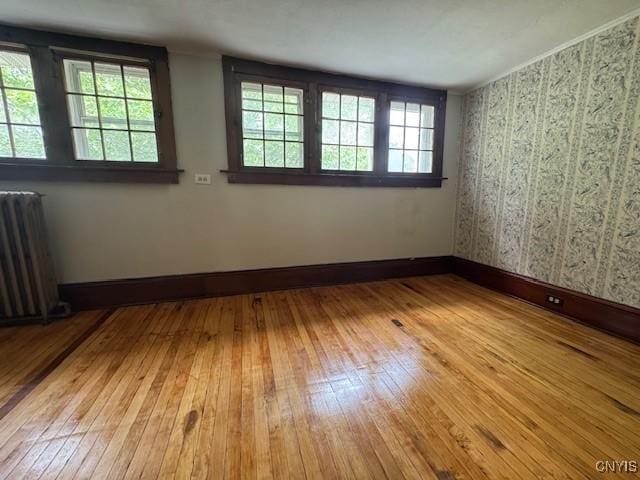 15 Broadway Ave, Cortland, NY 13045 - spare room with radiator heating unit, wood-type flooring, plenty of natural light, and wallpapered walls