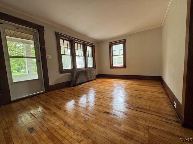 15 Broadway Ave, Cortland, NY 13045 - spare room with radiator heating unit, wood-type flooring, and ornamental molding