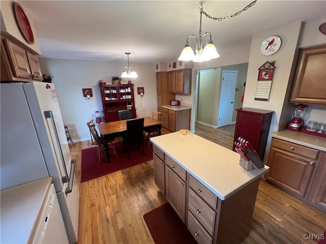 412 County Route 62, Sandy Creek, NY 13142 - kitchen with freestanding refrigerator, a chandelier, wood finished floors, light countertops, and a center island