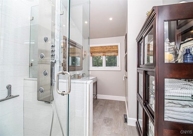 4458 E Lake Rd, Cazenovia, NY 13035 - bathroom featuring wood finished floors, a shower stall, and vaulted ceiling