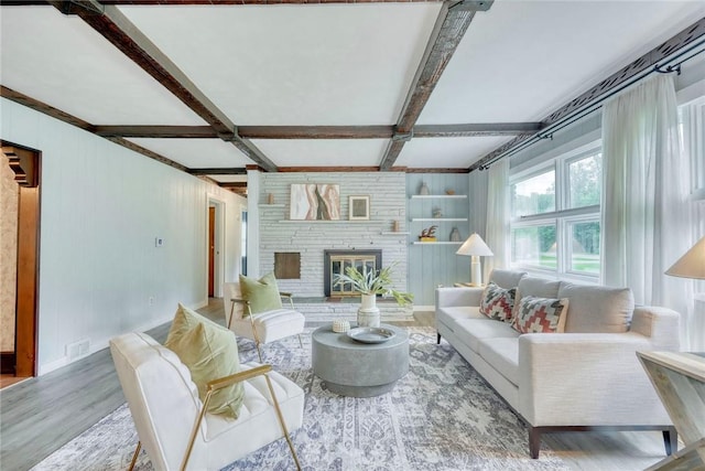 1541 Shoecraft Rd, Penfield, NY 14526 - living area with wood finished floors, beamed ceiling, a fireplace, built in shelves, and wooden walls