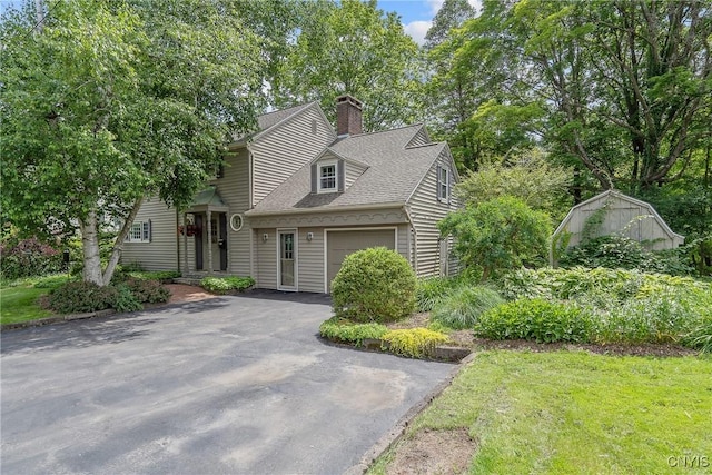 2 Morton Rd, Dewitt, NY 13214 - view of front facade featuring an attached garage, a chimney, asphalt driveway, and a shingled roof