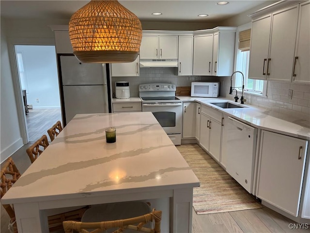 10 Montgomery St, Hamilton, NY 13346 - kitchen with white appliances, under cabinet range hood, light wood finished floors, decorative backsplash, and recessed lighting