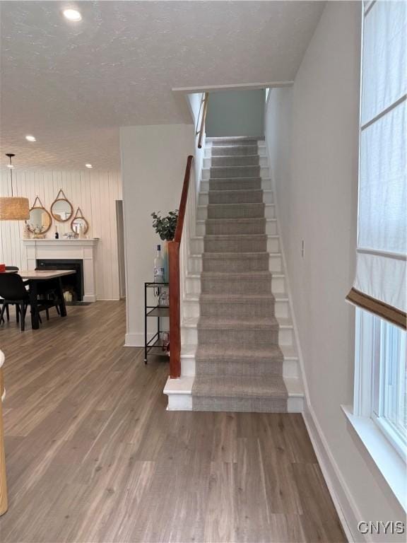 10 Montgomery St, Hamilton, NY 13346 - stairway with wood finished floors, recessed lighting, and a fireplace